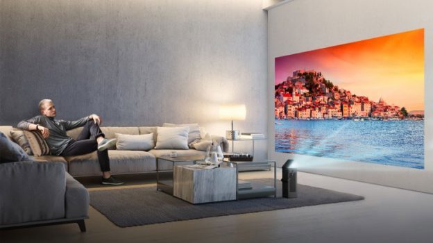 Mann sitzt auf Sofa und betrachtet Leinwand