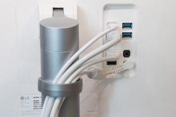 Die Kabel lassen sich mit dem Plastikclip vor oder hinter dem Standfuß platzieren