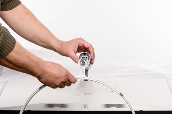 Der Fuß wird mit einer Flügelschraube am Arm fixiert