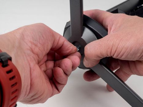Tragarm und Monitorfuß werden über eine Handschraube miteinander fixiert