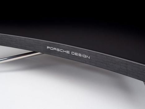 Edles und glänzendes Porsche-Design-Logo mittig am unteren Rahmen des AOC PD27