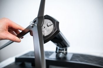 Tragarm und Monitorfuß werden über eine Handschraube miteinander fixiert